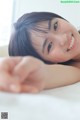 A woman laying on top of a bed smiling.