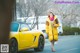 A woman in a yellow coat is walking by a yellow car.