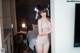 A woman in a blue and white bikini standing in front of a television.