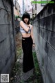 A woman standing in front of a concrete wall.